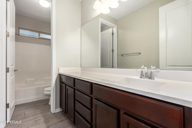 bathroom featuring toilet, bathing tub / shower combination, wood finished floors, and vanity