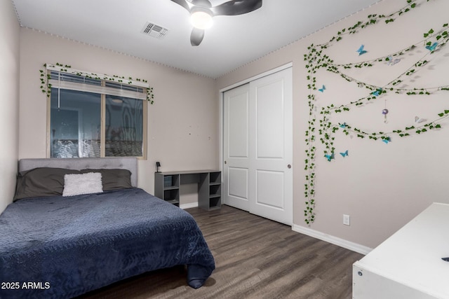 bedroom with wood finished floors, a ceiling fan, visible vents, baseboards, and a closet