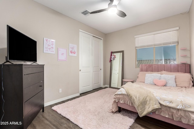 bedroom featuring a closet, visible vents, ceiling fan, wood finished floors, and baseboards