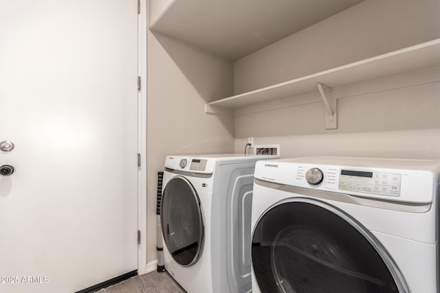 laundry room featuring baseboards, laundry area, washing machine and dryer, and light wood-style floors