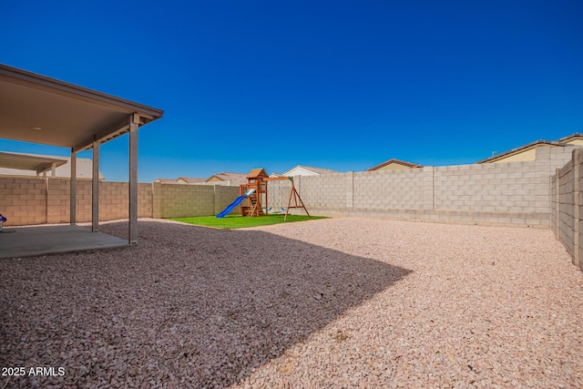 view of yard with a playground, a patio, and a fenced backyard