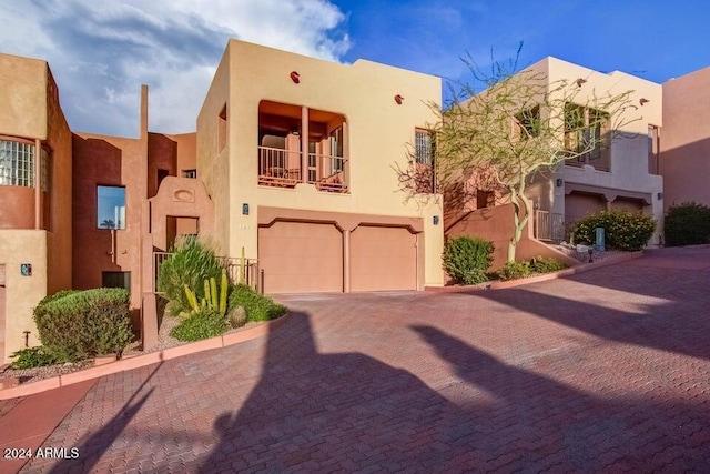 southwest-style home with a balcony and a garage