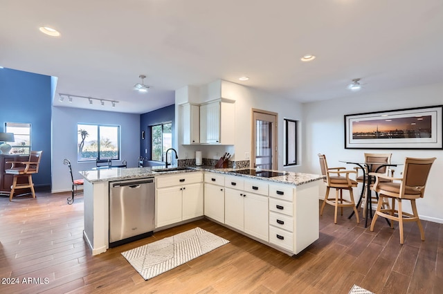 kitchen with kitchen peninsula, stainless steel dishwasher, sink, stone counters, and white cabinets