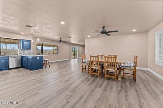 dining space with ceiling fan and light wood-type flooring