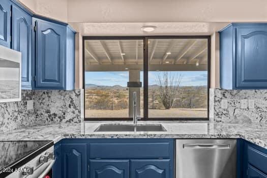 kitchen with stainless steel appliances, blue cabinetry, and plenty of natural light