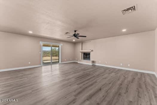 unfurnished living room with hardwood / wood-style flooring and ceiling fan