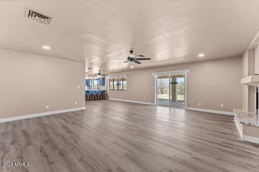 unfurnished living room featuring wood-type flooring and ceiling fan