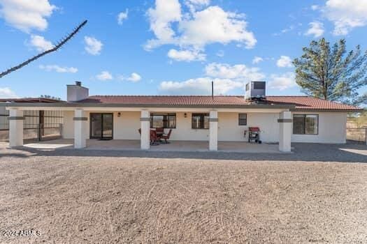 back of property with a patio and central AC