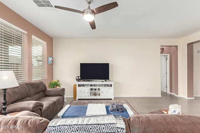 living area featuring visible vents, baseboards, and a ceiling fan