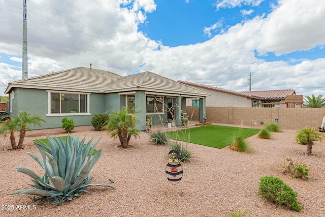 back of house featuring a patio area, a tiled roof, a fenced backyard, and stucco siding