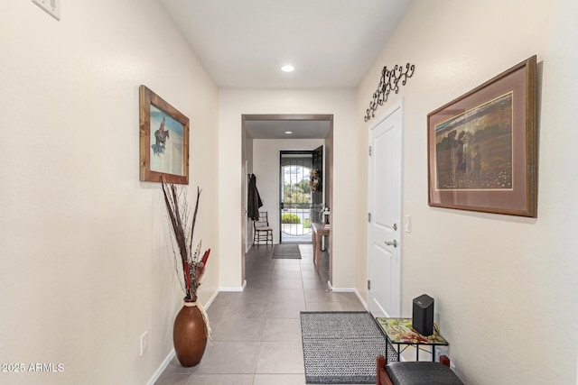 hallway featuring light tile patterned floors and baseboards