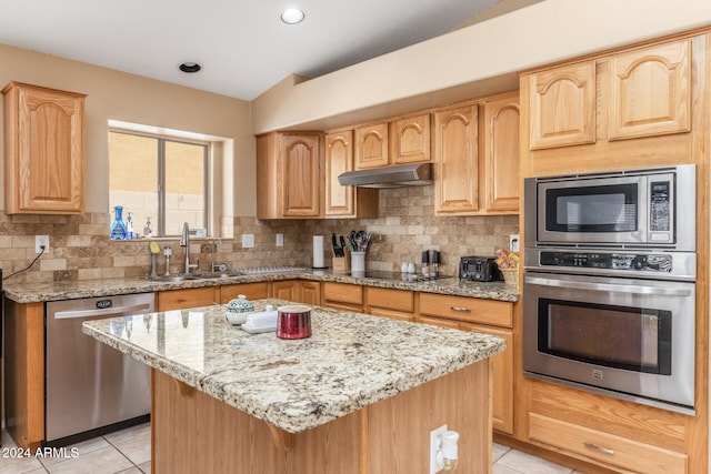 kitchen with a kitchen island, sink, decorative backsplash, and stainless steel appliances