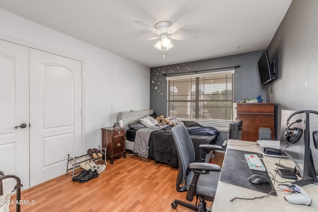 bedroom with hardwood / wood-style flooring, ceiling fan, and a closet