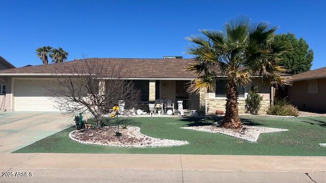 ranch-style house with a garage, driveway, and a front lawn
