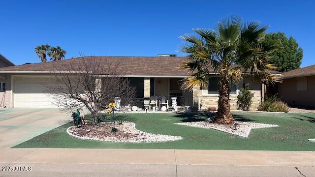 ranch-style house featuring a garage, a front lawn, and concrete driveway