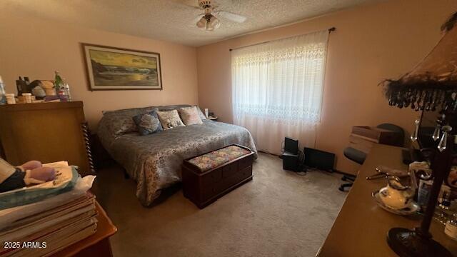 bedroom featuring carpet flooring, a textured ceiling, and ceiling fan