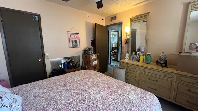 bedroom featuring a textured ceiling, ceiling fan, and visible vents