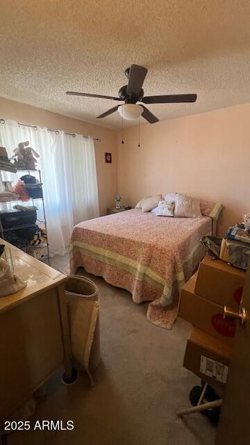 bedroom with a textured ceiling, ceiling fan, and carpet floors