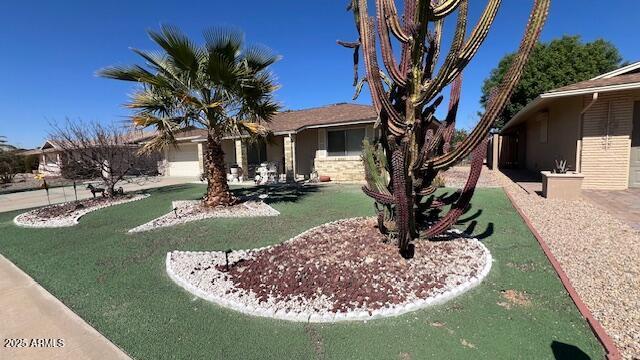 view of front of property featuring a garage, stucco siding, and stone siding