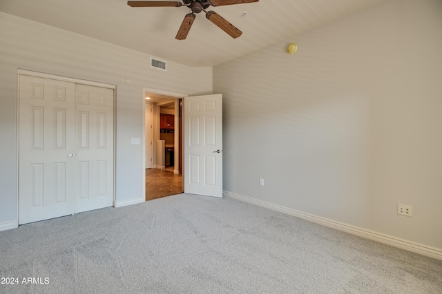 unfurnished bedroom with carpet, ceiling fan, and a closet