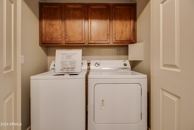 washroom featuring washer and clothes dryer and cabinets