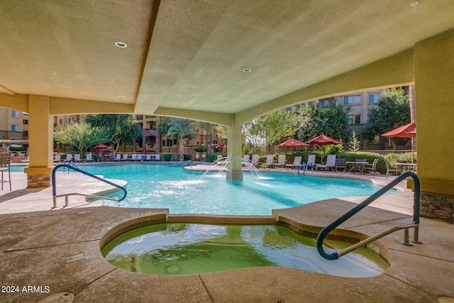 view of swimming pool with pool water feature, a community hot tub, and a patio