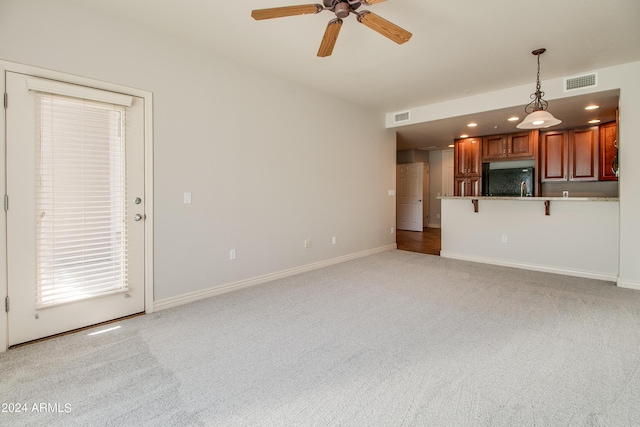 unfurnished living room with light carpet and ceiling fan