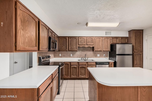 kitchen with light tile patterned flooring, a sink, visible vents, appliances with stainless steel finishes, and backsplash