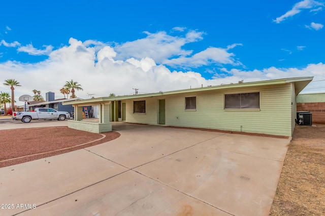 ranch-style home with a carport, central AC, and driveway