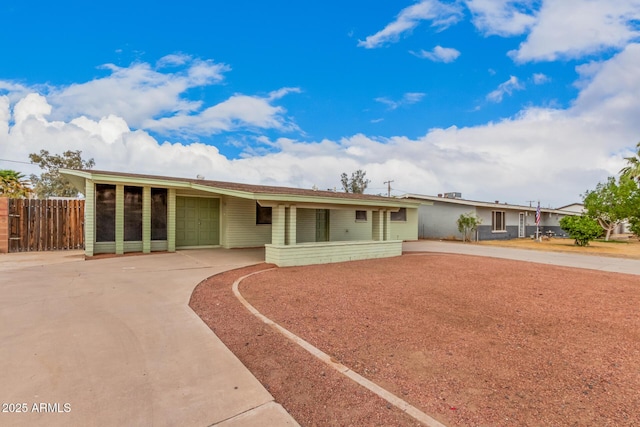 view of front of property featuring driveway and fence