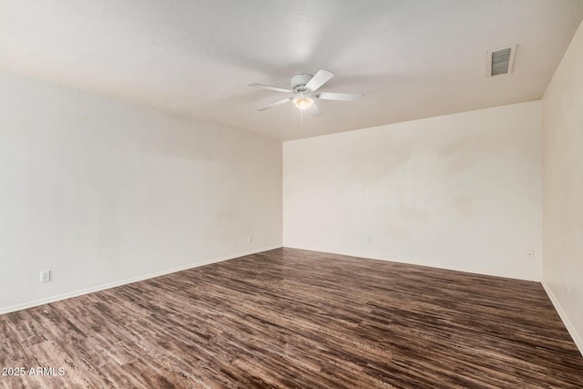 empty room with visible vents, dark wood finished floors, baseboards, and ceiling fan