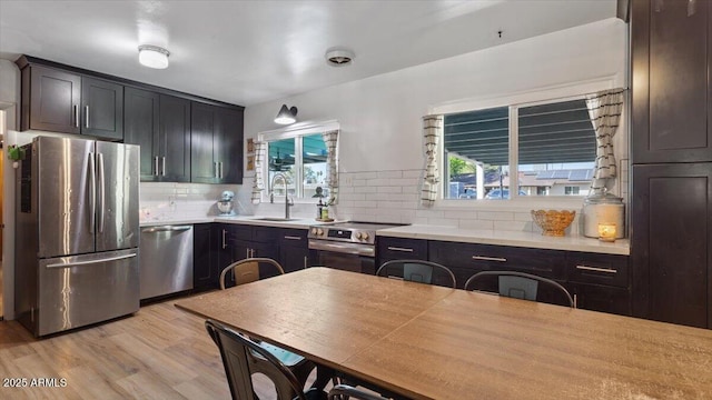 kitchen with a wealth of natural light, appliances with stainless steel finishes, light wood-style floors, and a sink