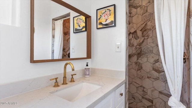 full bath with tiled shower and vanity