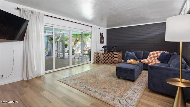 living area featuring brick wall and wood finished floors