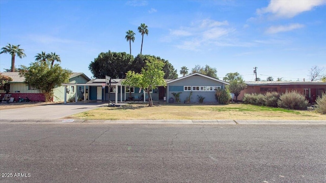 view of front of house featuring a carport, driveway, and a front lawn