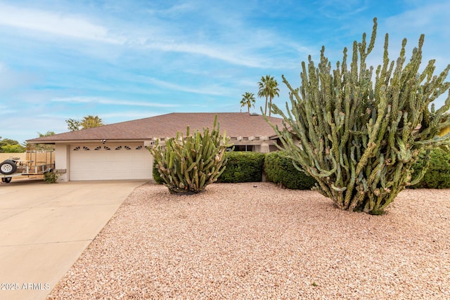 view of front facade featuring stucco siding, concrete driveway, and an attached garage