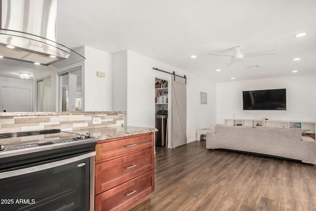 kitchen with dark wood finished floors, a barn door, decorative backsplash, range hood, and electric range