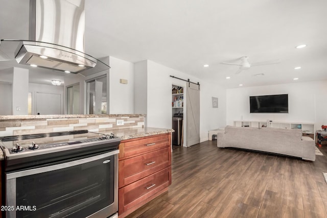 kitchen featuring electric range, island exhaust hood, a barn door, decorative backsplash, and dark wood-style flooring