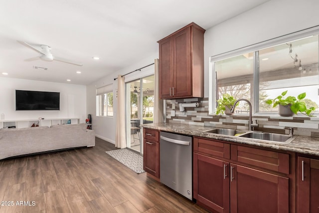 kitchen with recessed lighting, a sink, decorative backsplash, dark wood-type flooring, and stainless steel dishwasher