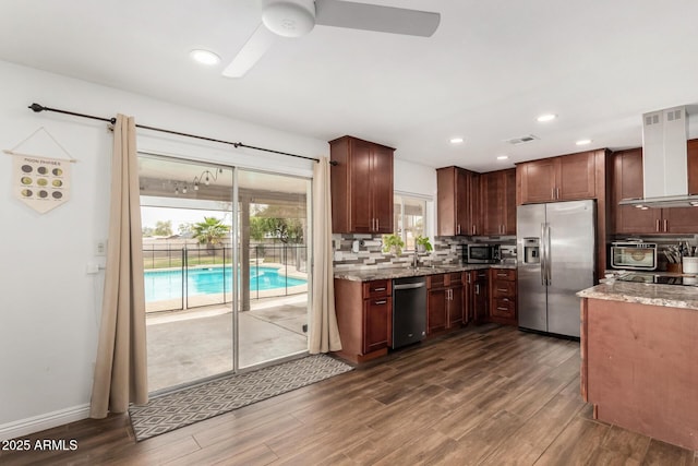 kitchen with visible vents, backsplash, appliances with stainless steel finishes, wall chimney exhaust hood, and dark wood-style flooring