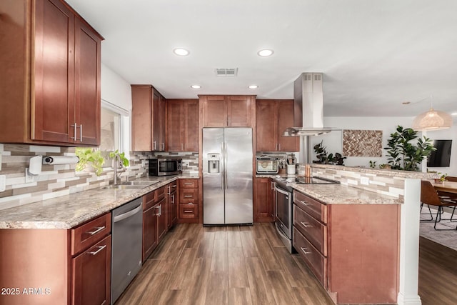 kitchen featuring visible vents, a peninsula, a sink, stainless steel appliances, and island range hood