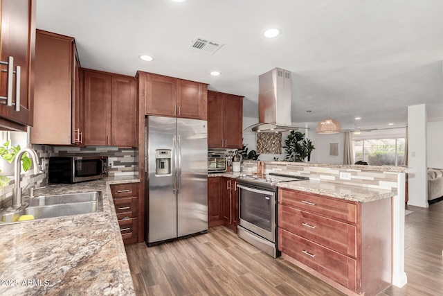 kitchen with visible vents, a sink, appliances with stainless steel finishes, a peninsula, and island range hood