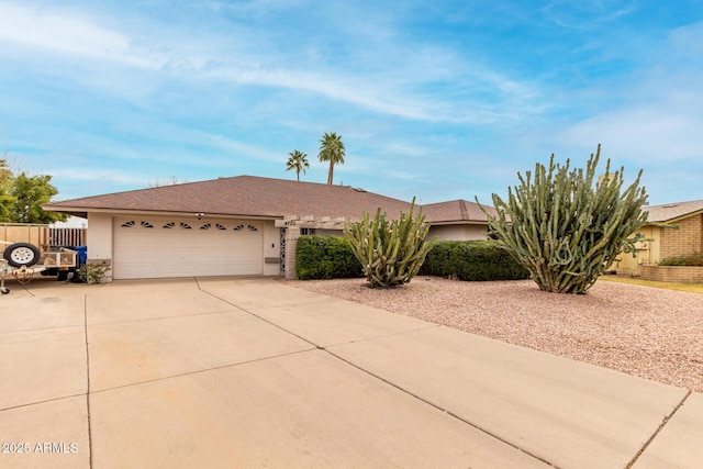 view of front facade featuring a garage, fence, driveway, and stucco siding