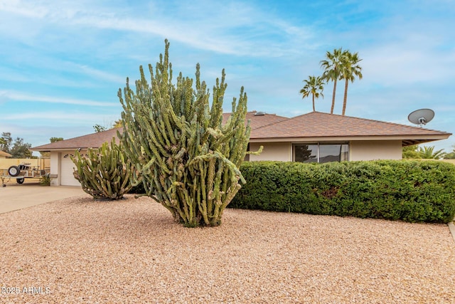 view of front of property with stucco siding, driveway, and a garage