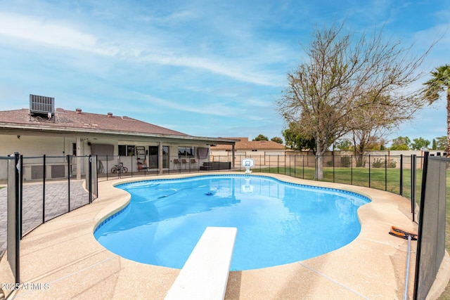 view of swimming pool featuring a patio, fence, a fenced in pool, a diving board, and central AC