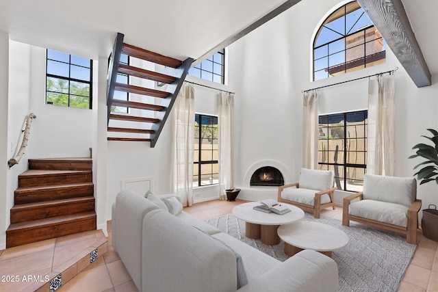 8844 S 51st St Unit 3, Phoenix, AZ 85044 - tiled living area featuring stairs, a towering ceiling, and a lit fireplace