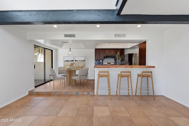 8844 S 51st St Unit 3, Phoenix, AZ 85044 - kitchen featuring a kitchen breakfast bar, freestanding refrigerator, recessed lighting, decorative backsplash, and visible vents