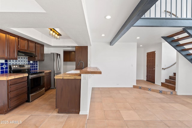 8844 S 51st St Unit 3, Phoenix, AZ 85044 - kitchen featuring decorative backsplash, a peninsula, under cabinet range hood, tile counters, and stainless steel appliances