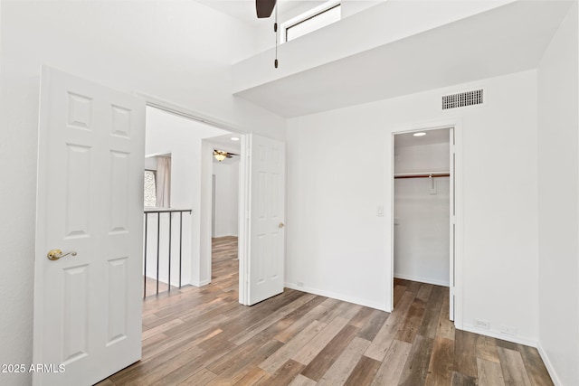 8844 S 51st St Unit 3, Phoenix, AZ 85044 - unfurnished bedroom with a spacious closet, baseboards, wood finished floors, and visible vents