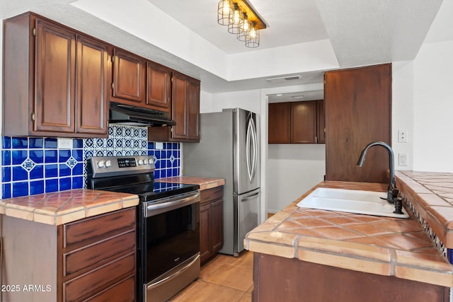 8844 S 51st St Unit 3, Phoenix, AZ 85044 - kitchen featuring appliances with stainless steel finishes, a sink, tile counters, backsplash, and under cabinet range hood